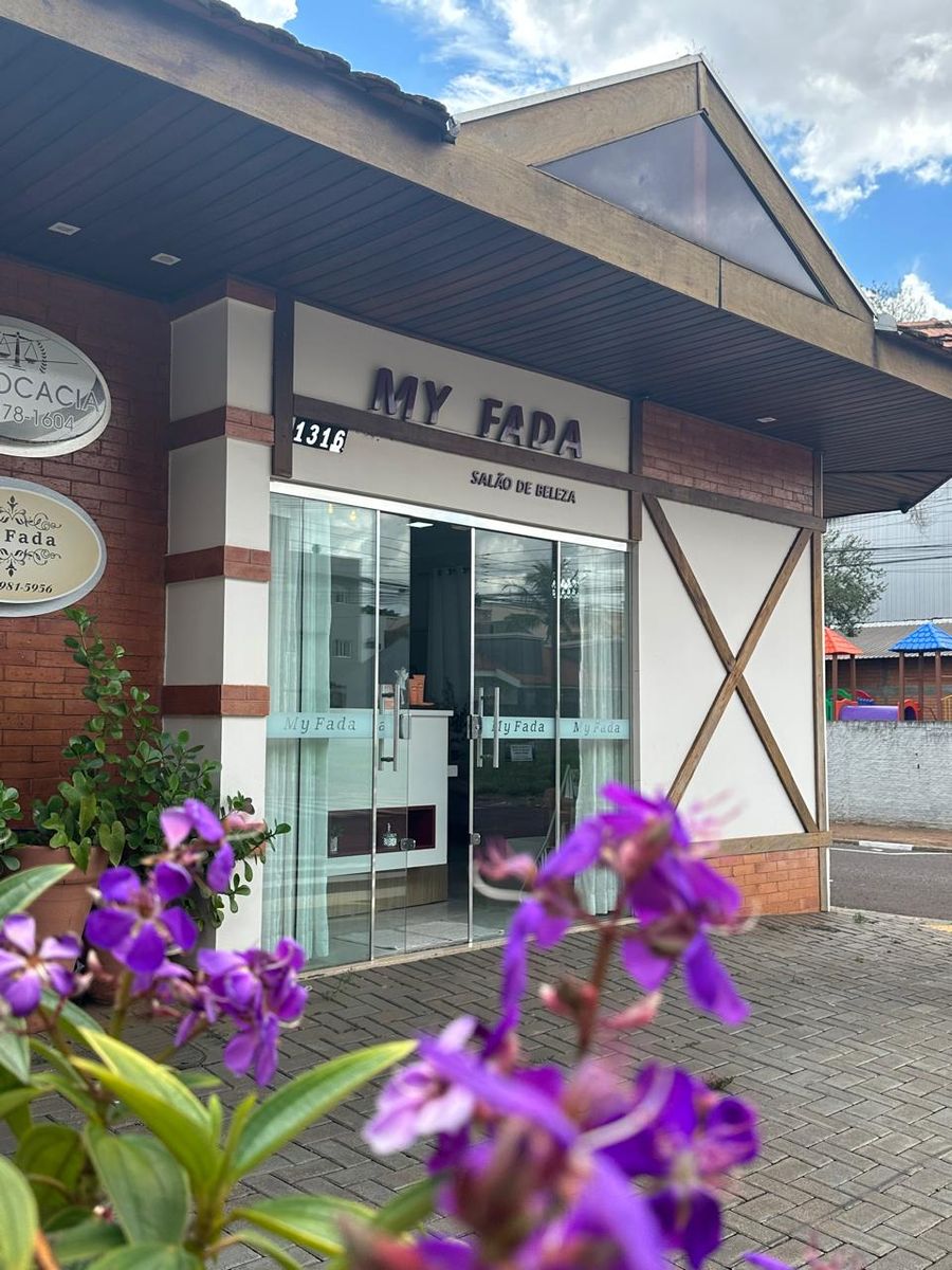 Fachada do My Fada com flores roxas na frente